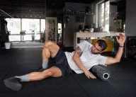 A person using a foam roller, one of the most effective recovery tools for improving mobility and circulation.