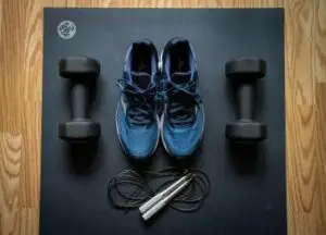 Home gym essentials for beginners: A starter kit with dumbbells, jumping rope, and athletic shoes.
