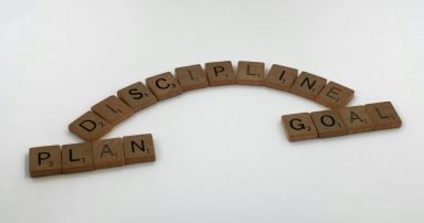 Scrabble tiles spelling out Plan, Discipline, and Goal to build fitness habits.