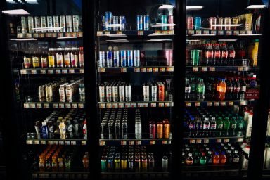 Stocked gym refrigerator containing sugar-free energy drinks for working out.