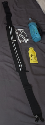 Fitgriff running belt laid out flat with a energy gel and water bottle.